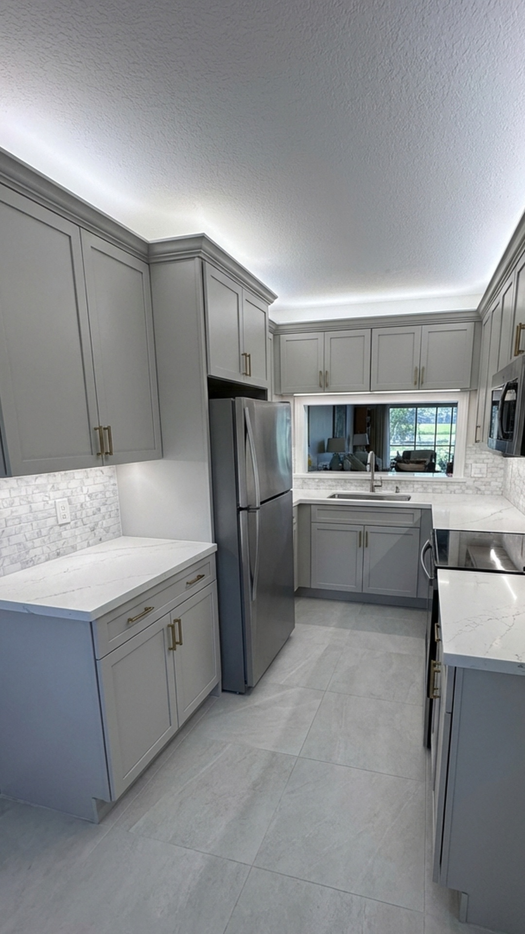 Kitchen remodel in Jupiter, FL featuring marble mosaic tile backsplash and large-format floor tile by MELTINI Remodeling